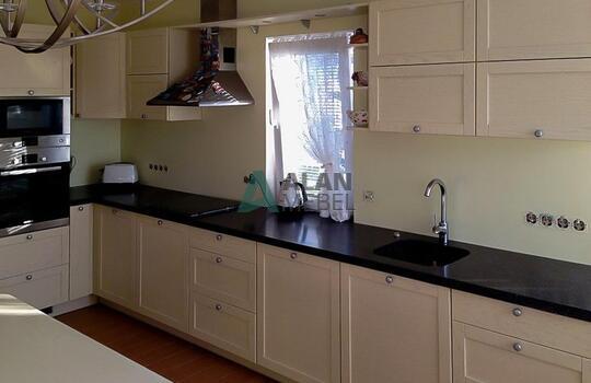 Г-образная кухня молочного цвета с матовыми рамочными фасадами и черной столешницей на заказ 