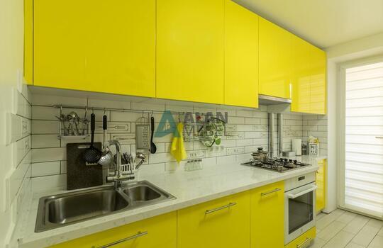 Желтая кухня без ручек со встроенной техникой 